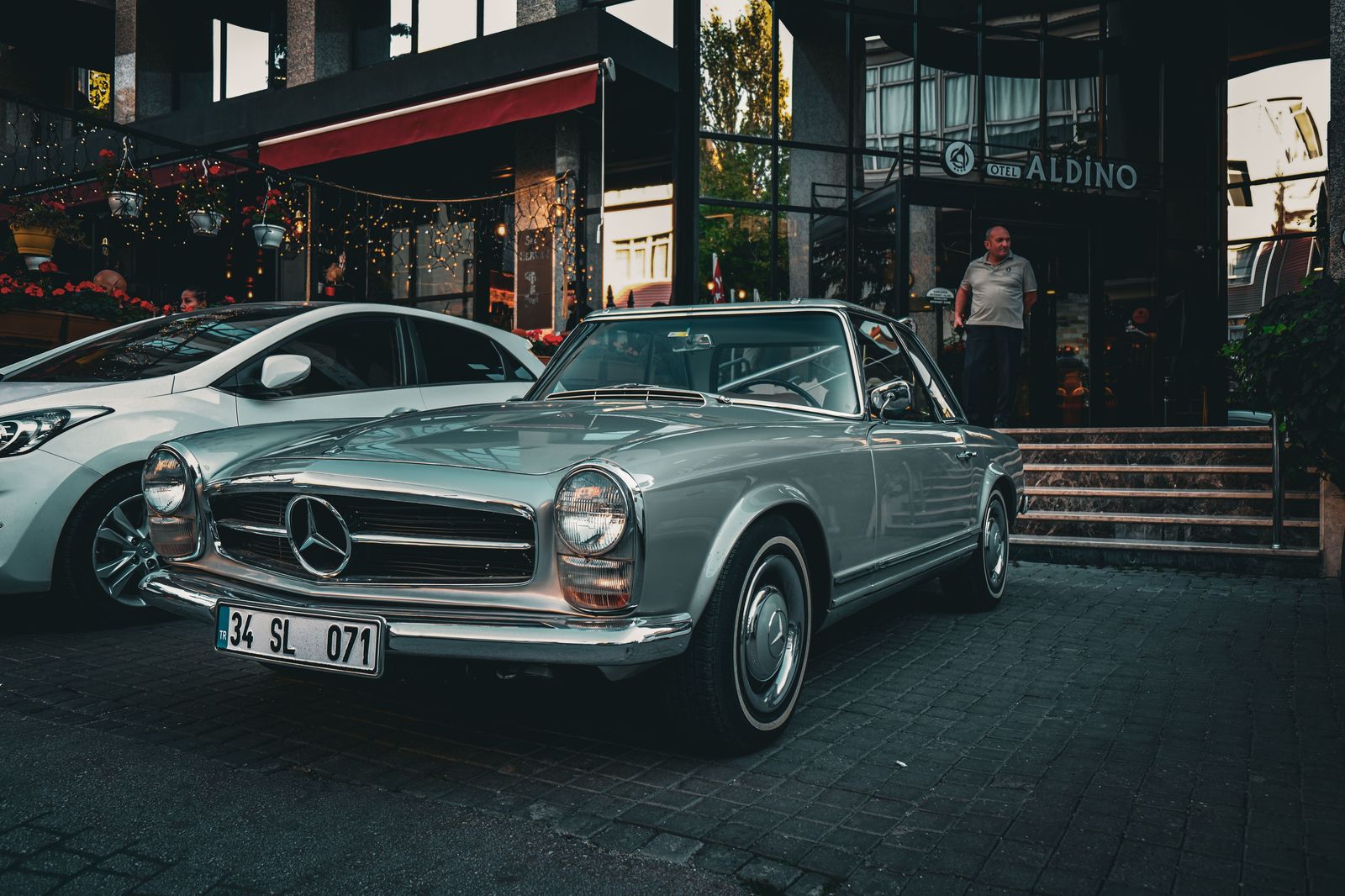 A car waiting outside a hotel entrance in the evening