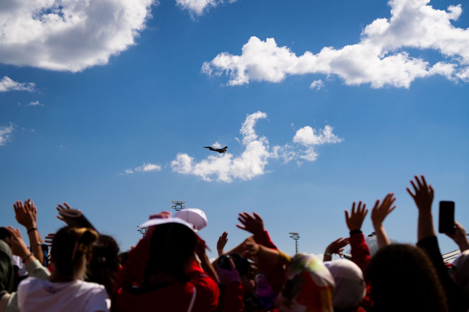 A crowd watching a vintage aircraft on the ground at an airfield event