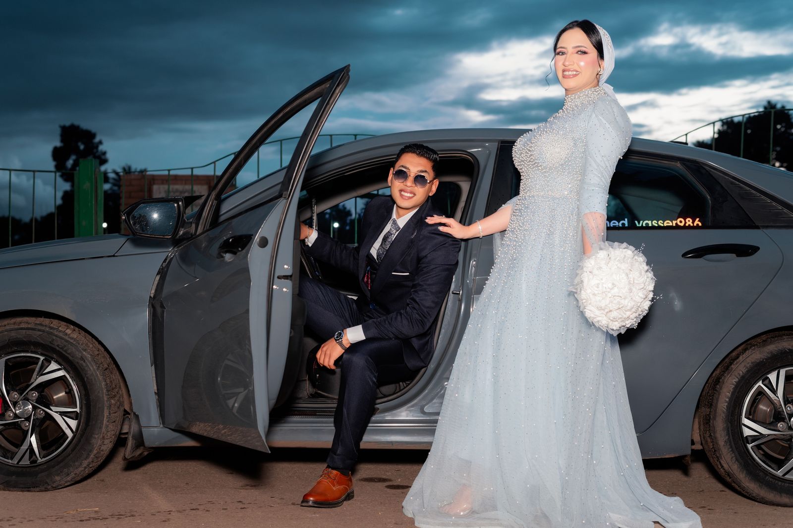 Newlyweds leaving their reception in a black car at the end of the night