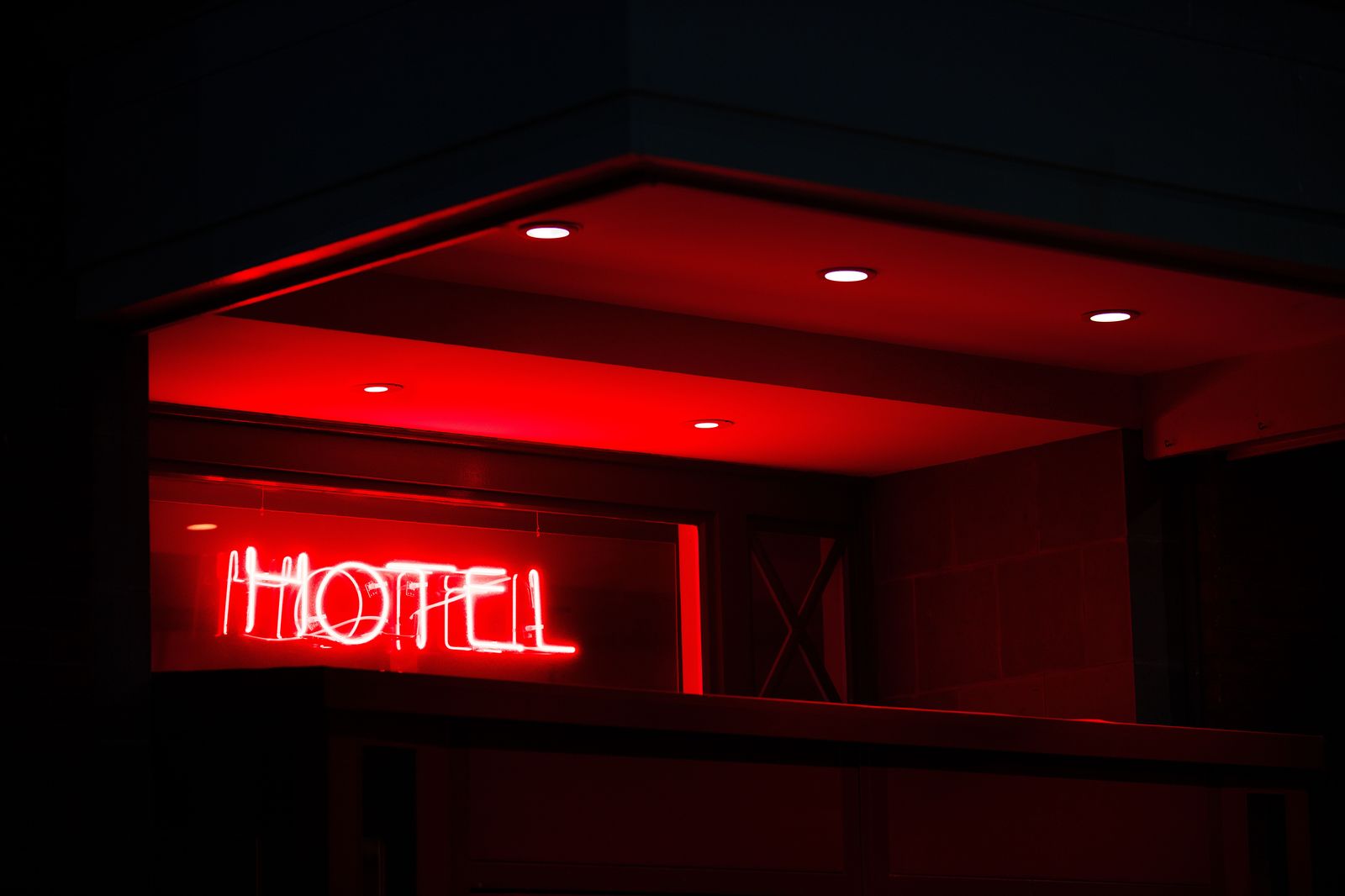 The canopy entrance of a hotel in the evening, where a chauffeur waits for a client