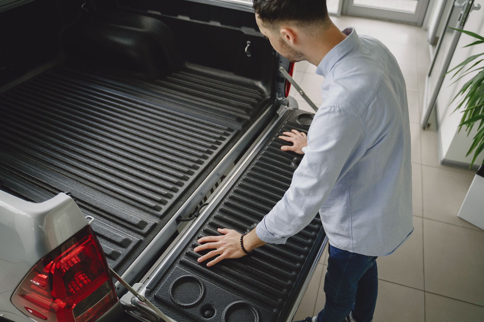 A chauffeur loading a suitcase into the trunk of a black sedan