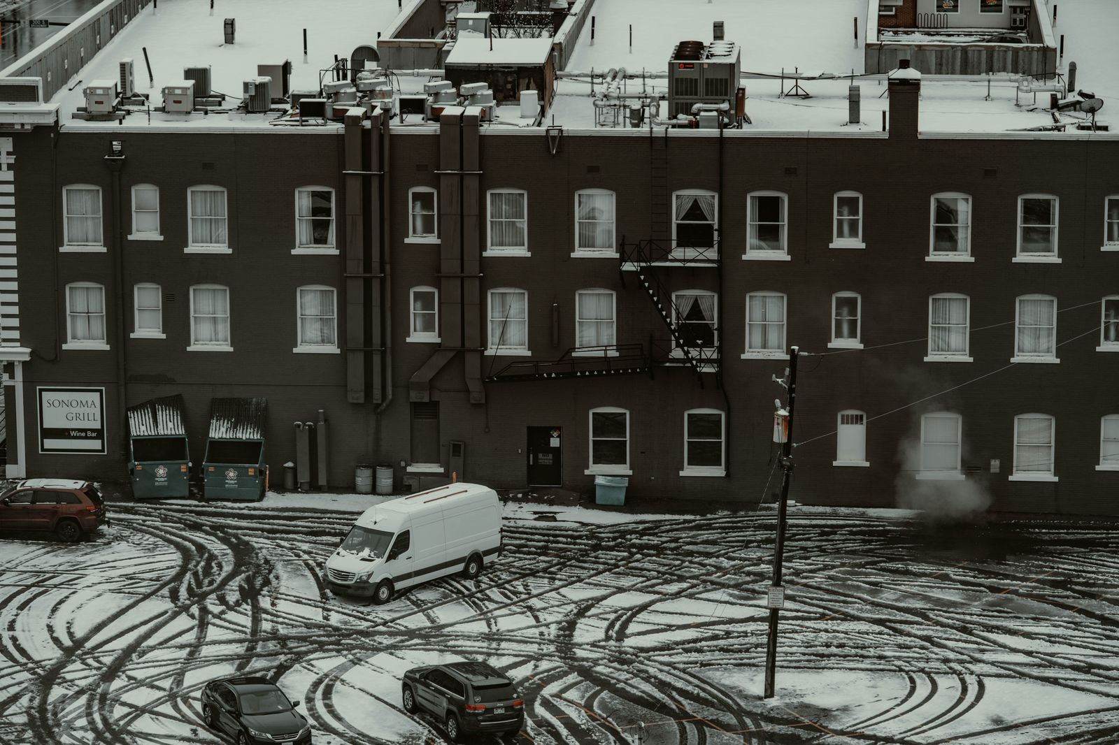 Black SUV waiting on a snowy street in the evening
