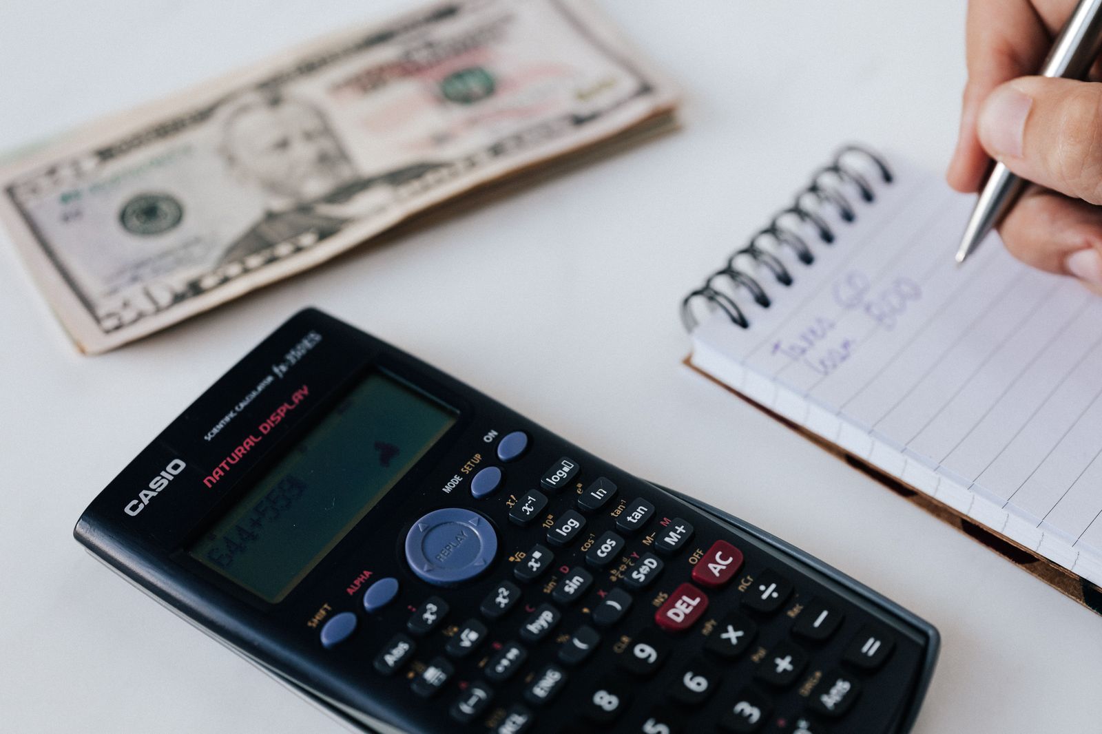 A notebook and calculator used to compare the cost of a chauffeur with other options