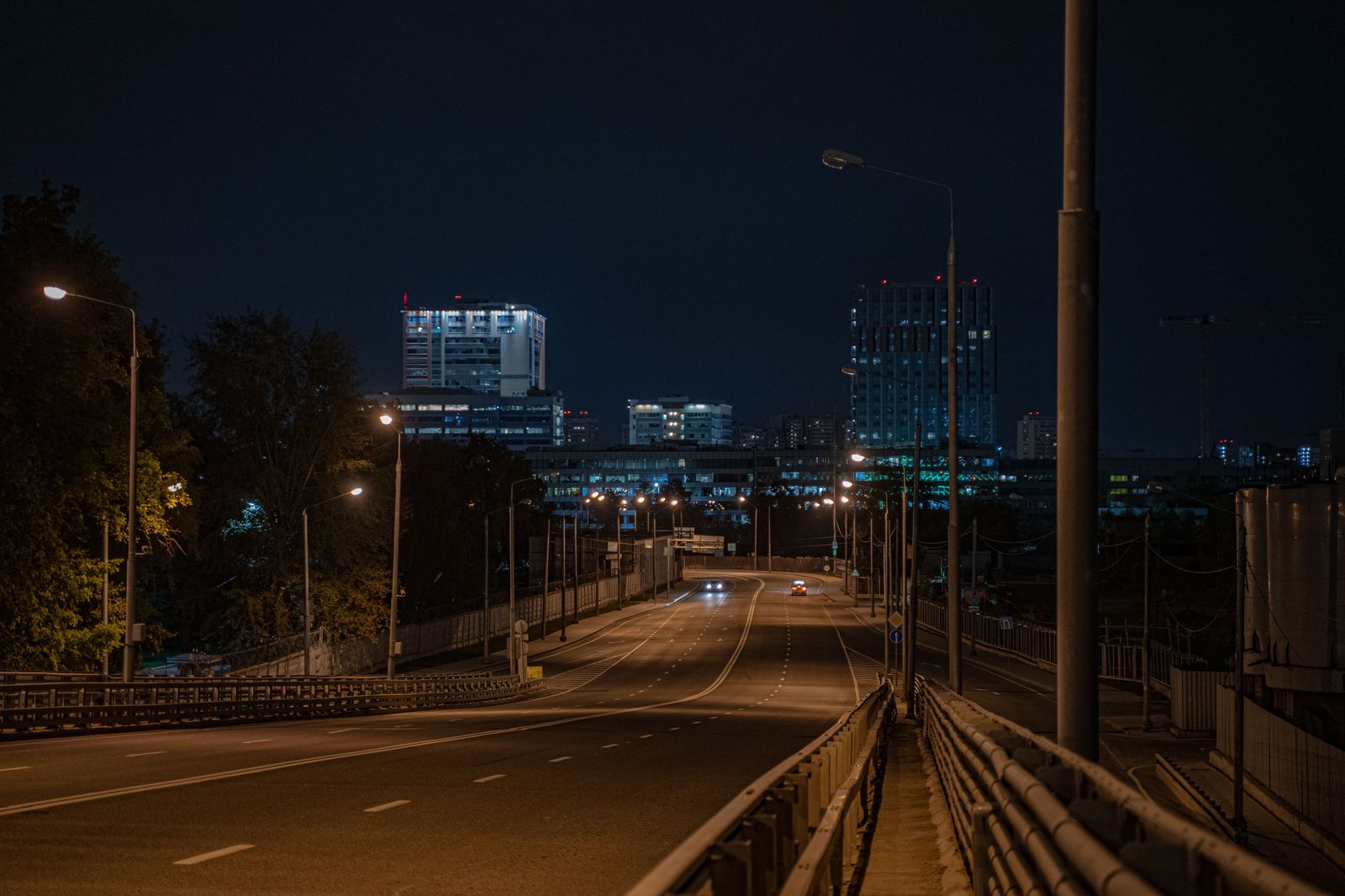 An empty highway at night with streetlights stretching into the distance