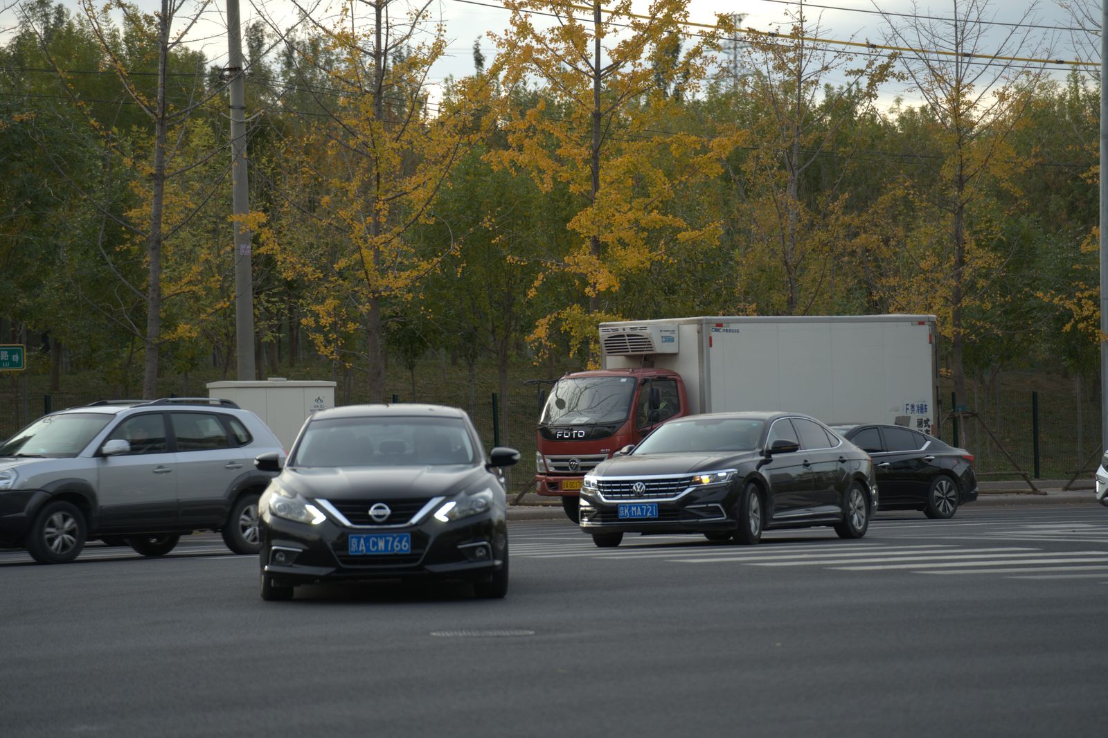 A black sedan on a rural Ontario highway in autumn