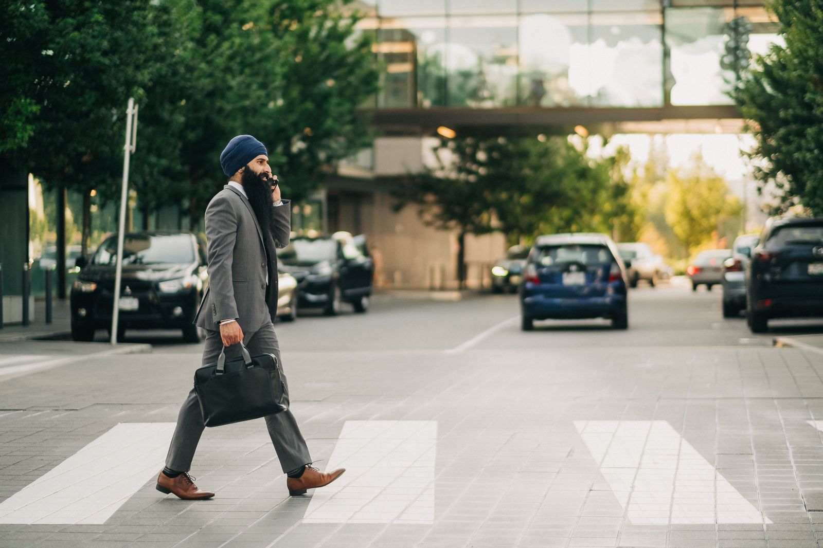A businessman walking to a waiting black car in the city