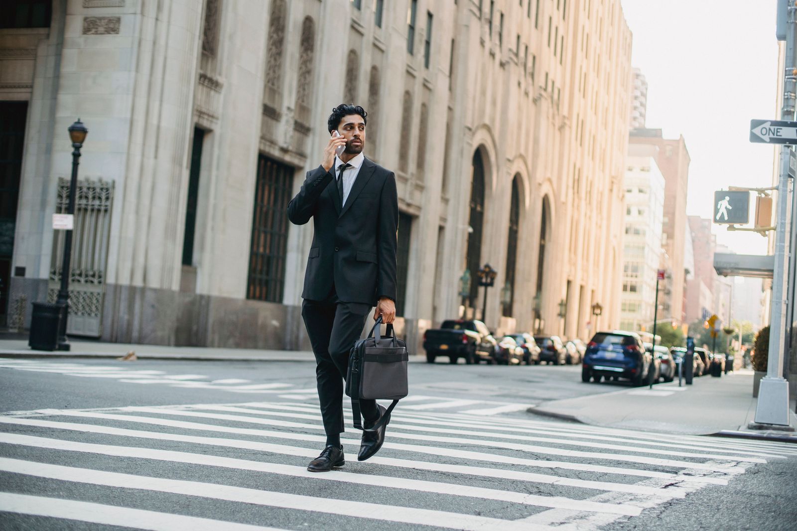 A business traveller walking with a rolling suitcase along a downtown street