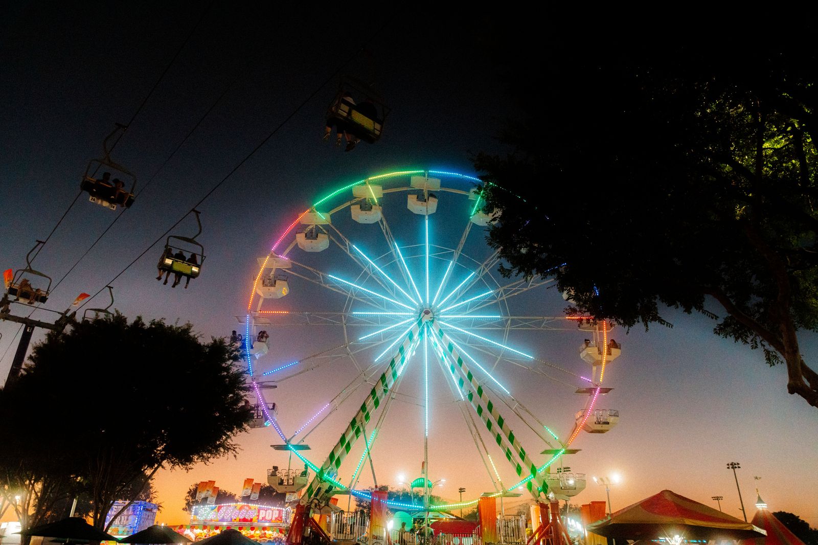 A fall fair midway lit up at dusk, the kind of weekend when an hourly chauffeur saves the parking hunt.