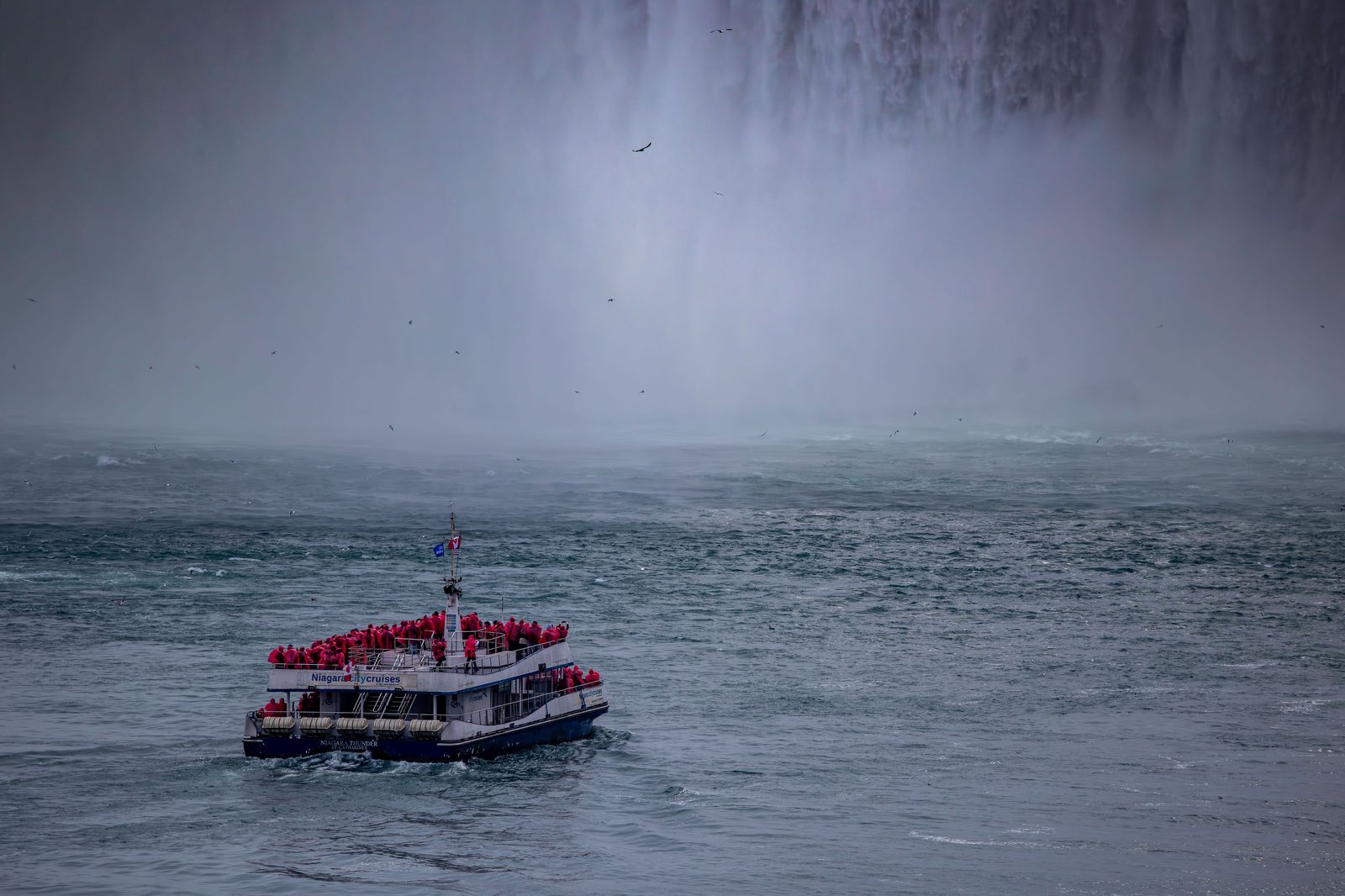 The boat tour heading into the mist below the Falls while the chauffeur waits at an agreed point.