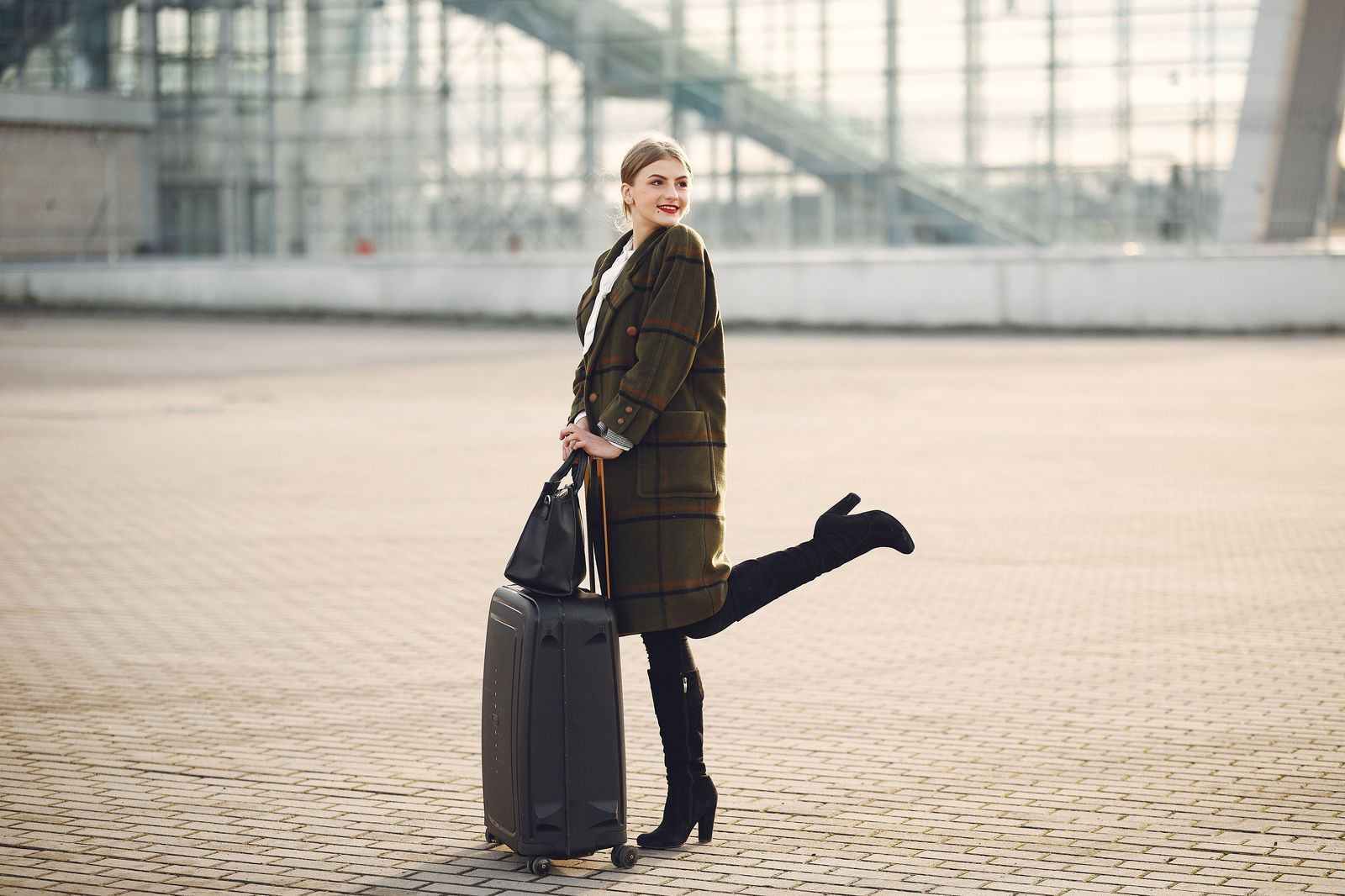 A traveller with a suitcase coming out of airport arrivals to meet a chauffeur
