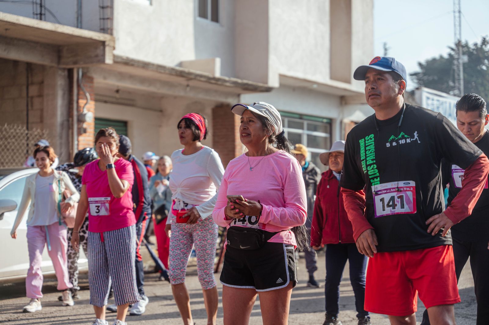 Runners gathered at a race start line on an early autumn morning