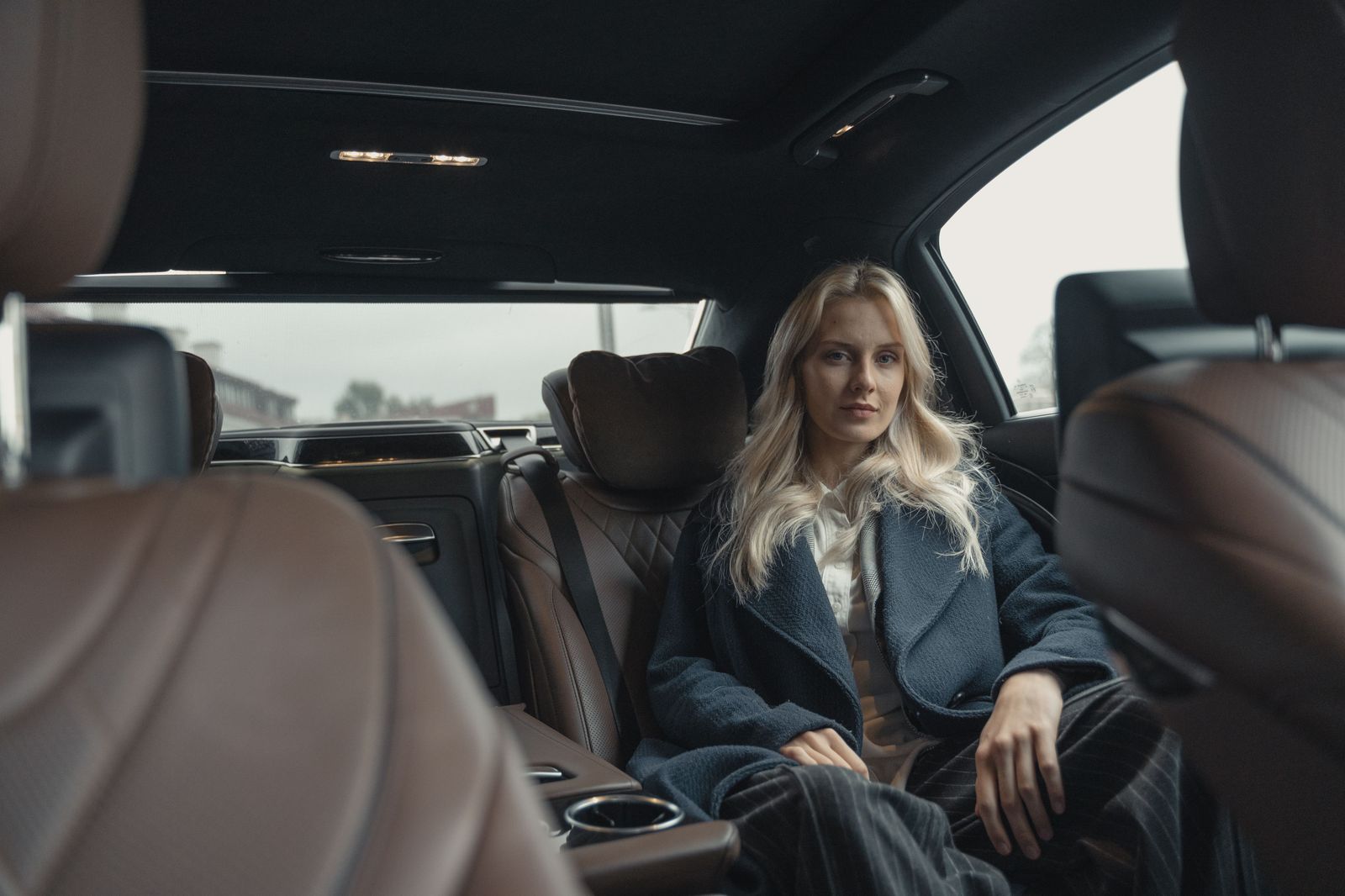 An executive relaxing in the back seat of a luxury car