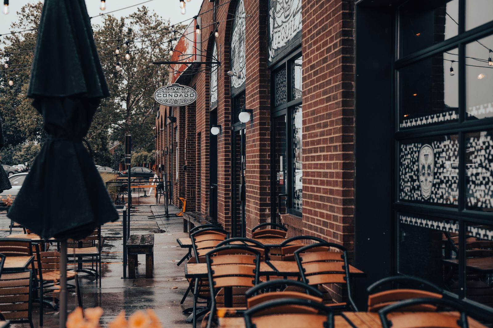 A brick-fronted street with café patios on a warm evening in downtown Hamilton