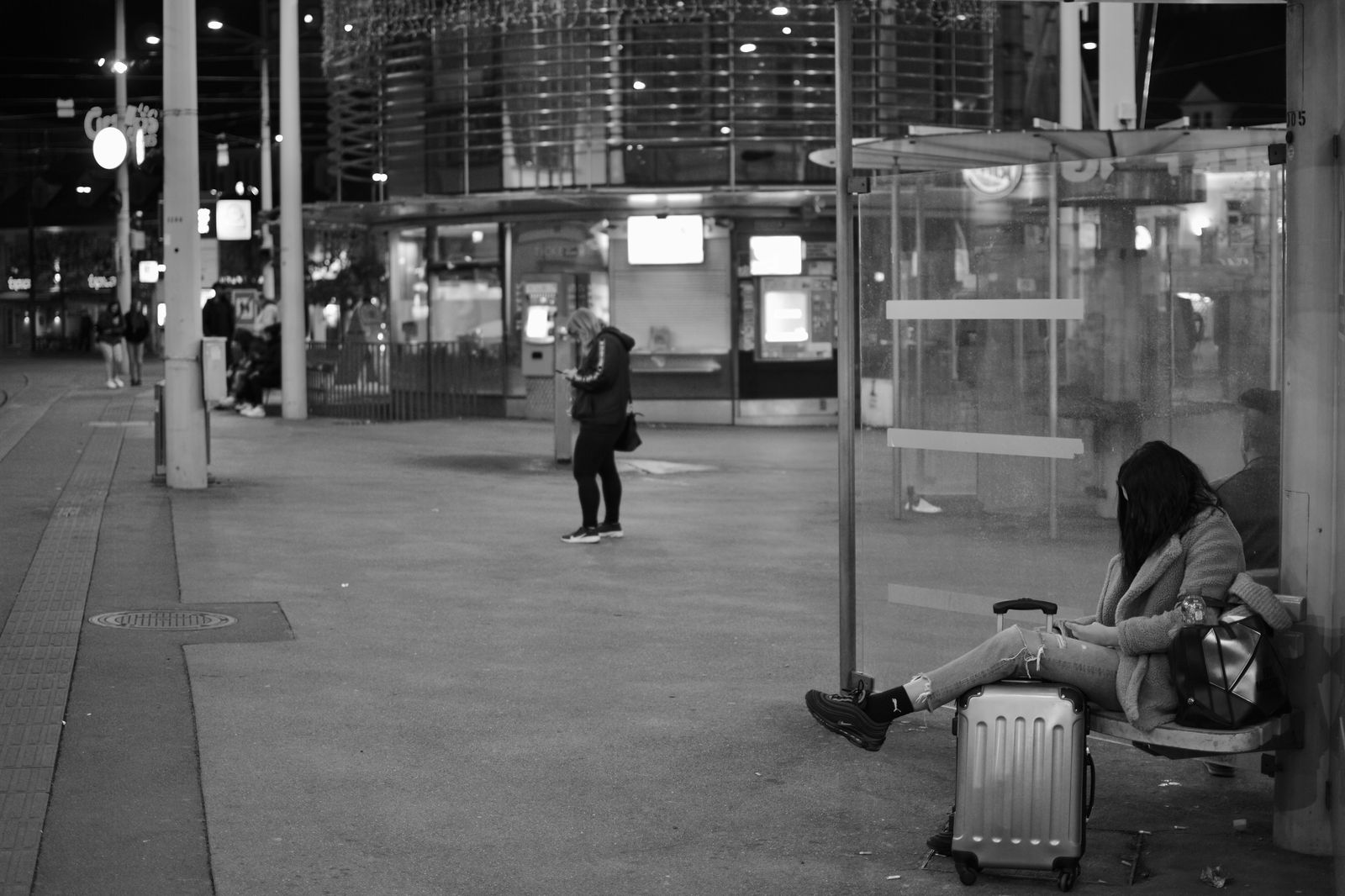 A traveller with a suitcase waiting at a regional bus stop