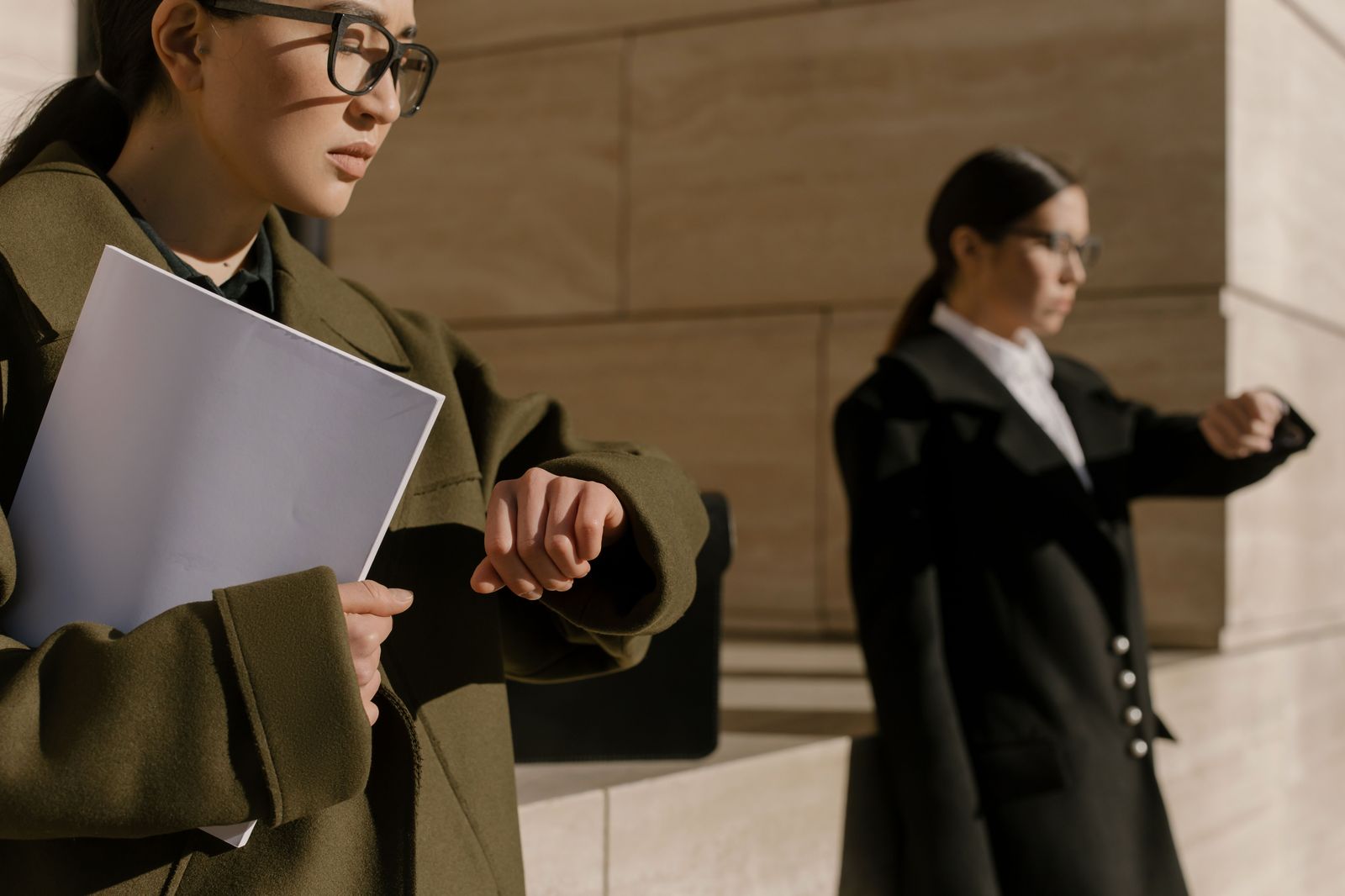 A professional checking the time between meetings while her chauffeur waits nearby