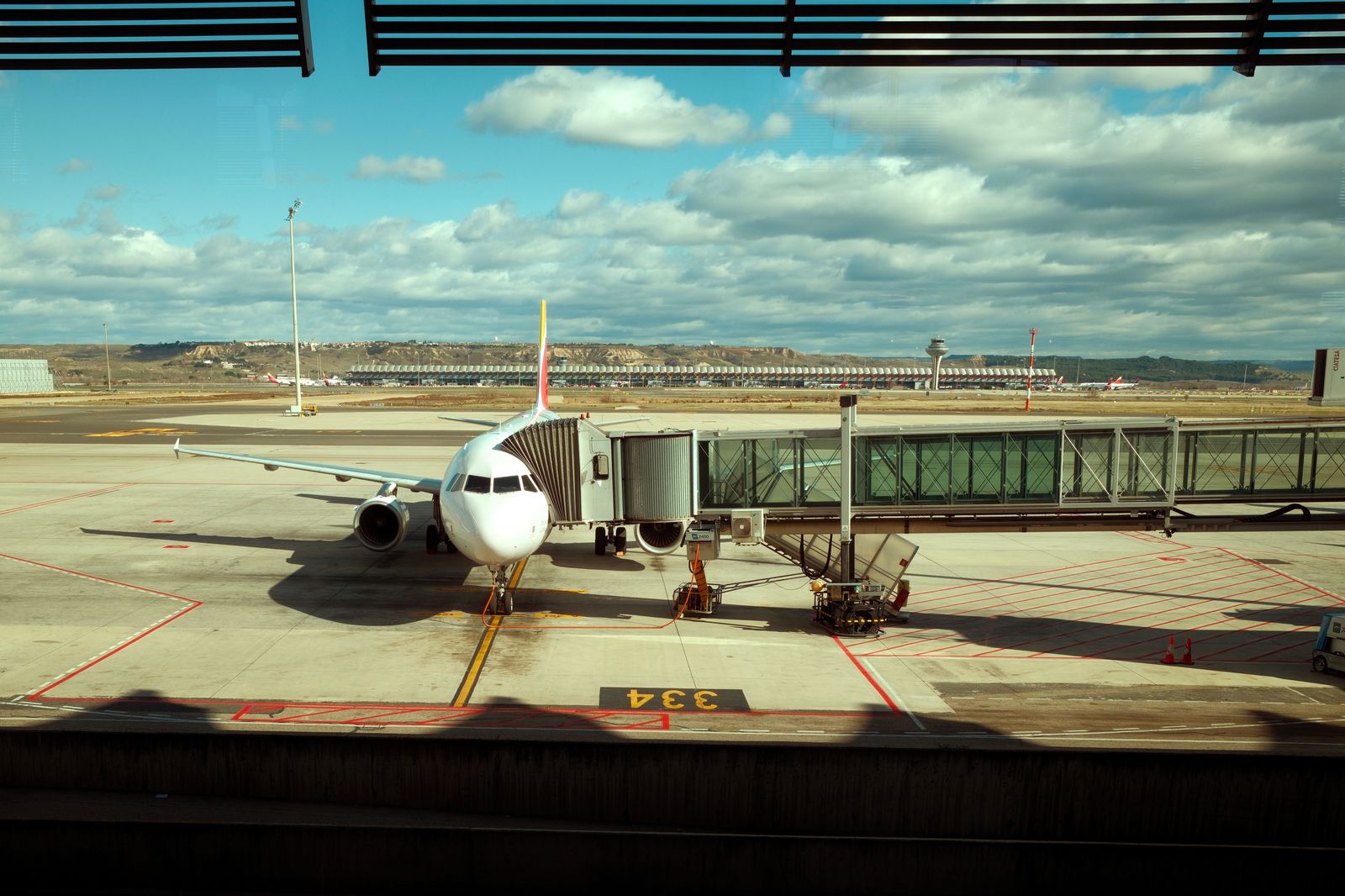 Passengers walking through a jet bridge to board their flight