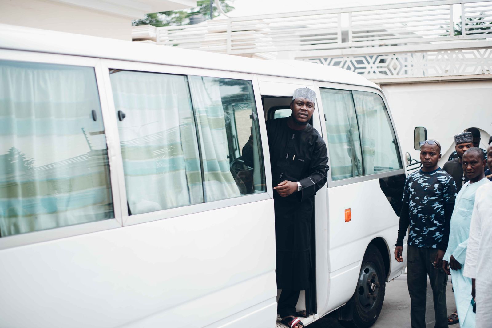 Wedding guests boarding a chauffeured van outside a lakefront hotel