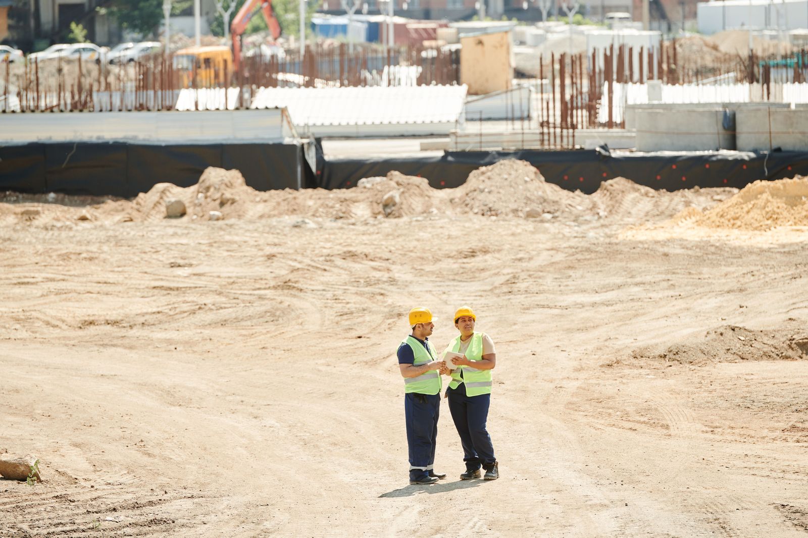 Workers in hard hats and high-visibility vests at an industrial site