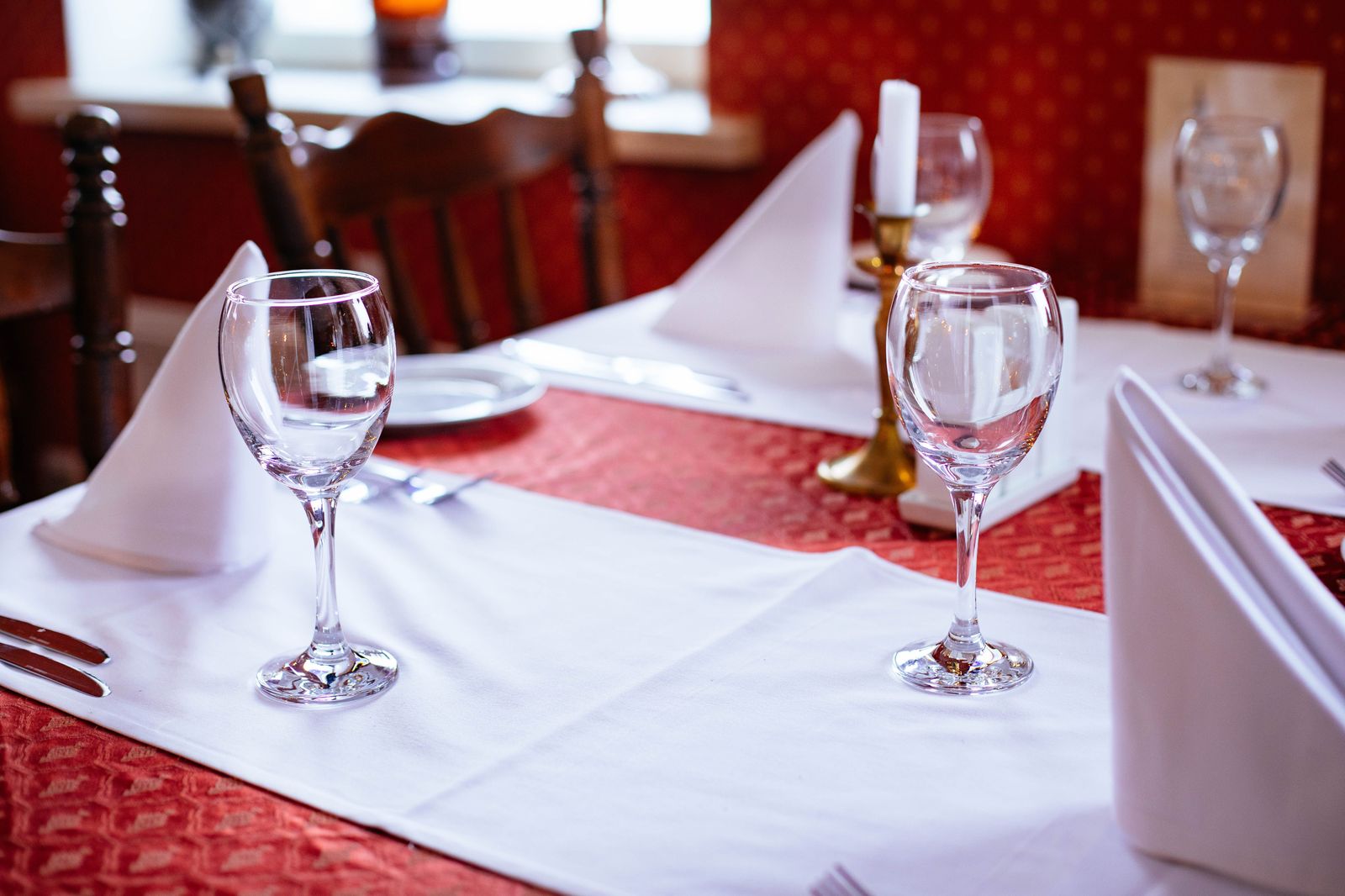 A candlelit table for two set for dinner in a restaurant