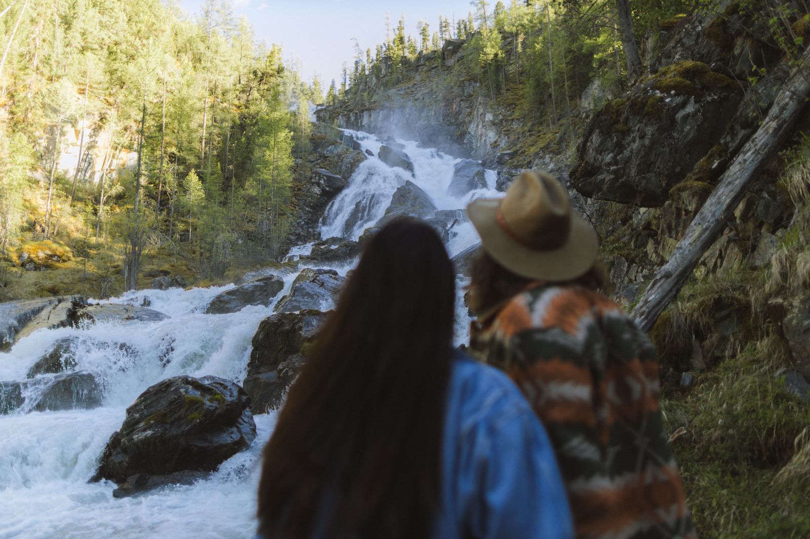 A couple watching an illuminated waterfall at night