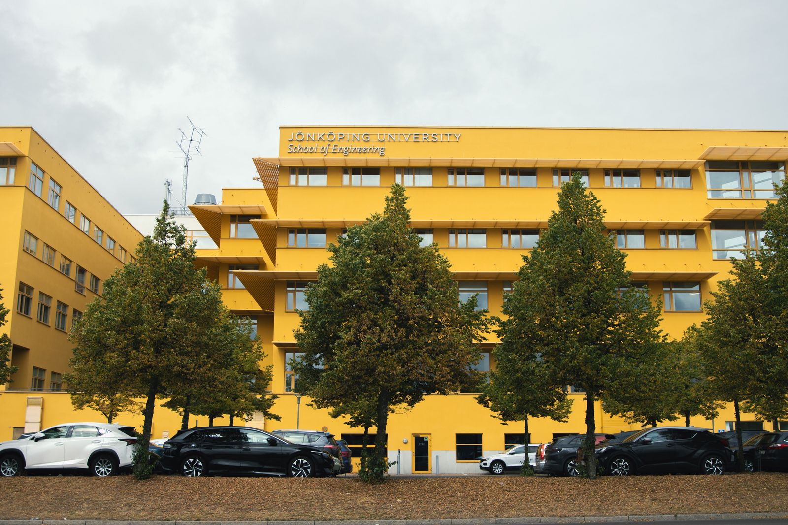 A black SUV waiting beside a university building