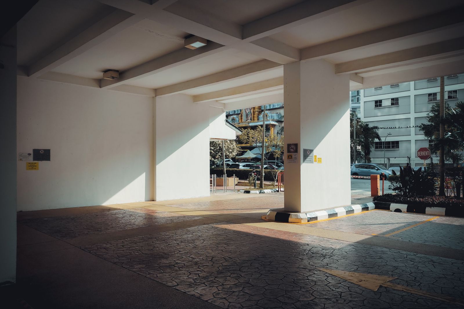 A covered hospital entrance with a drop-off lane for cars