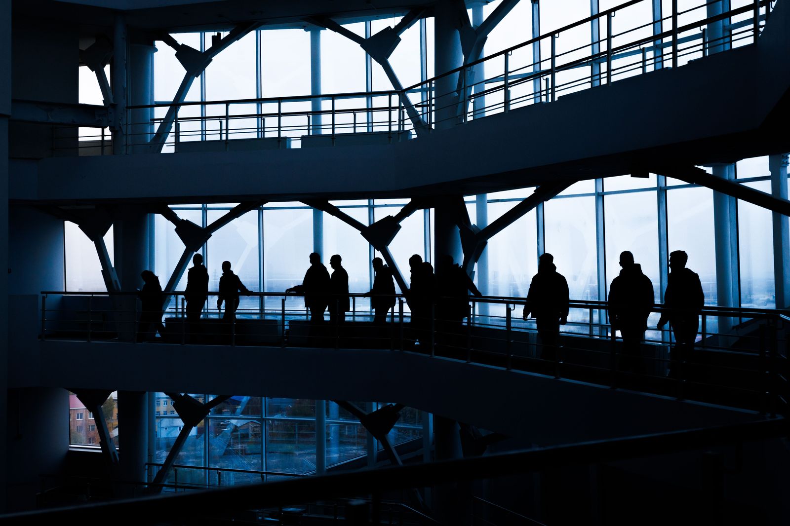 Business people walking out of a glass office building to their car