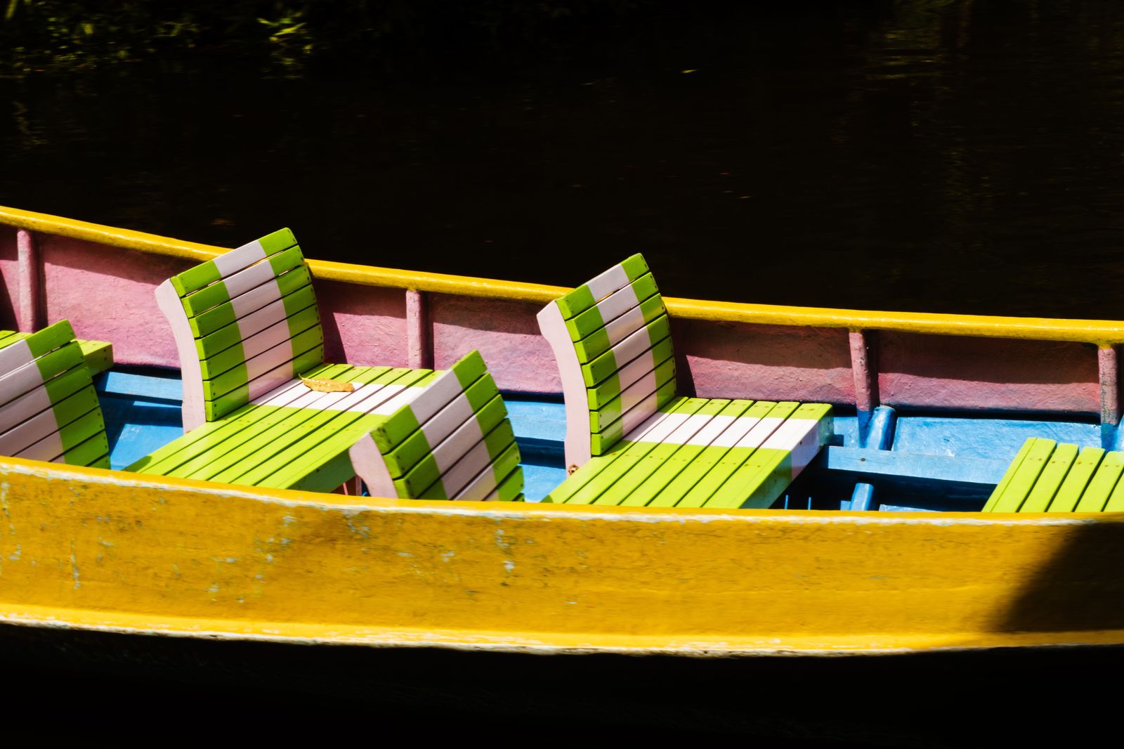 Wooden boat on a calm Muskoka lake with dock chairs