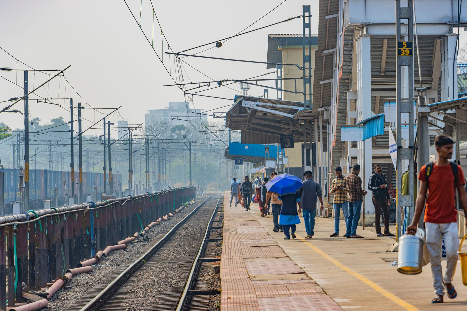 Passengers waiting on a railway platform as a train approaches