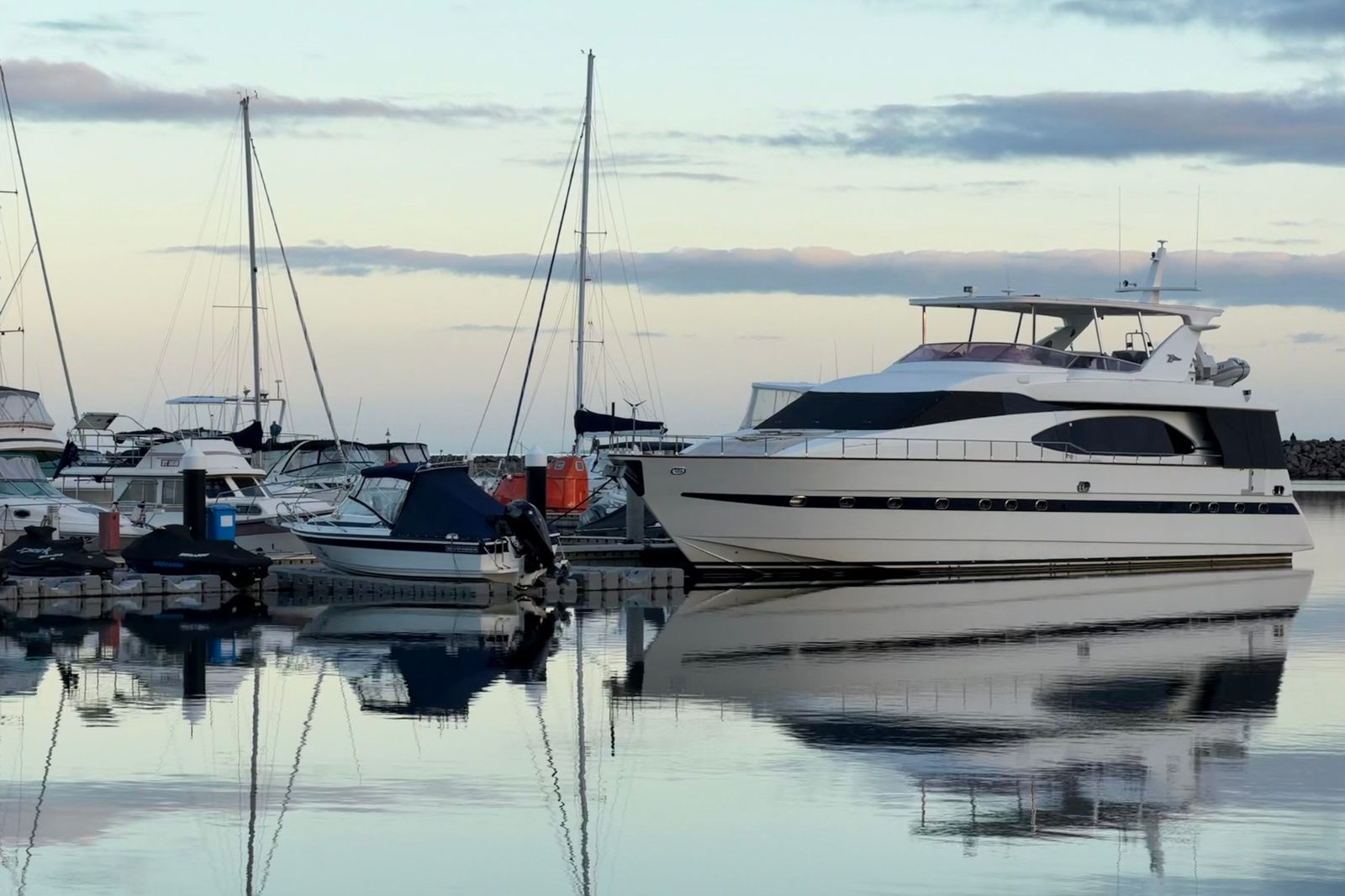 Boats in a harbour marina at sunset near a Hamilton train station