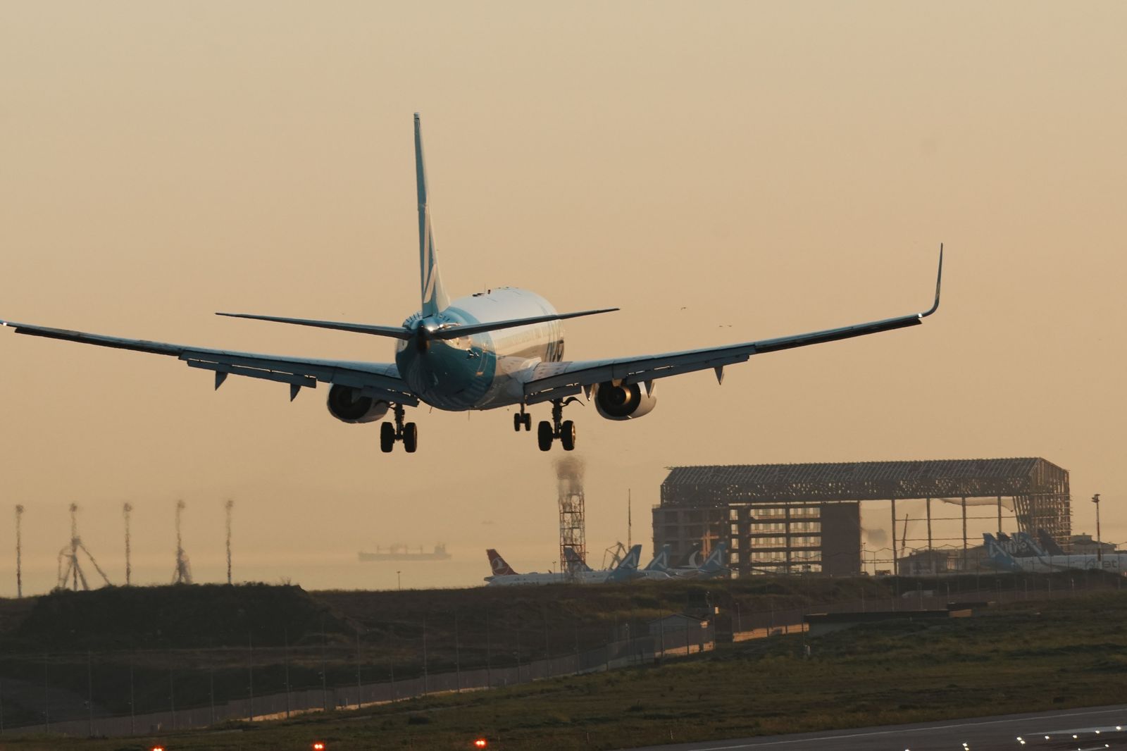 An airliner on final approach at dusk, the moment flight tracking times the chauffeur's arrival