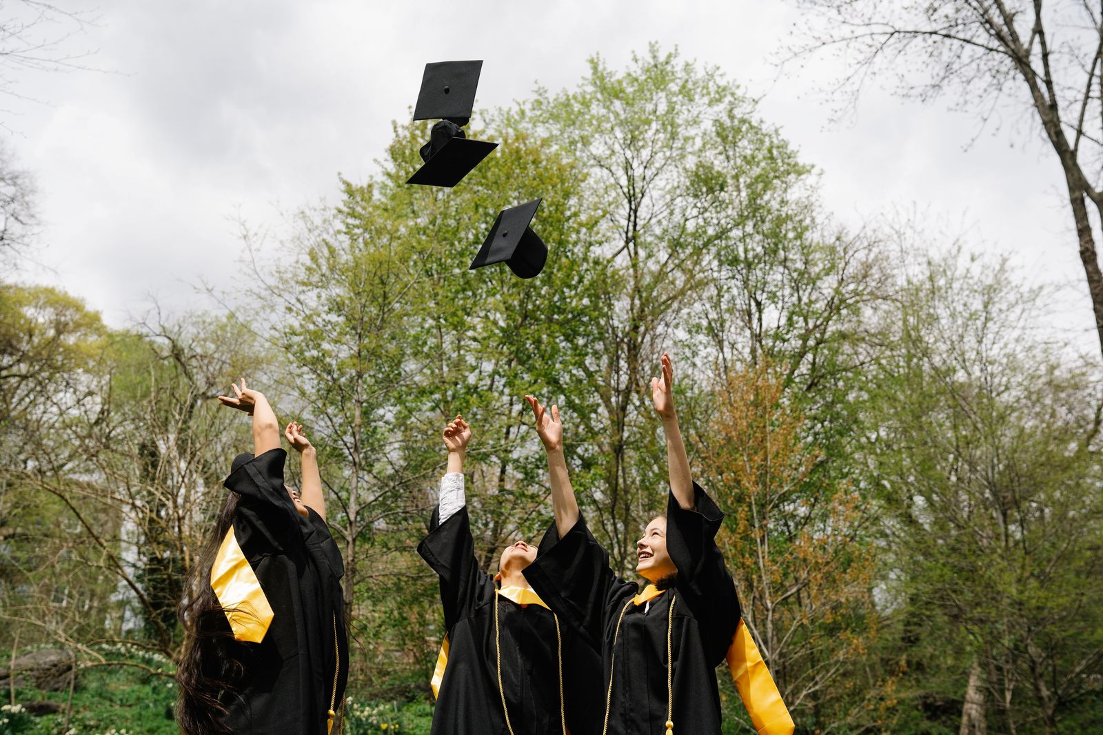Graduates throwing caps in the air at a Hamilton graduation