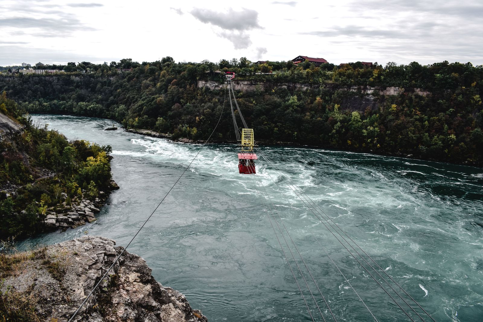 Cars crossing a steel arch bridge high above the Niagara River gorge