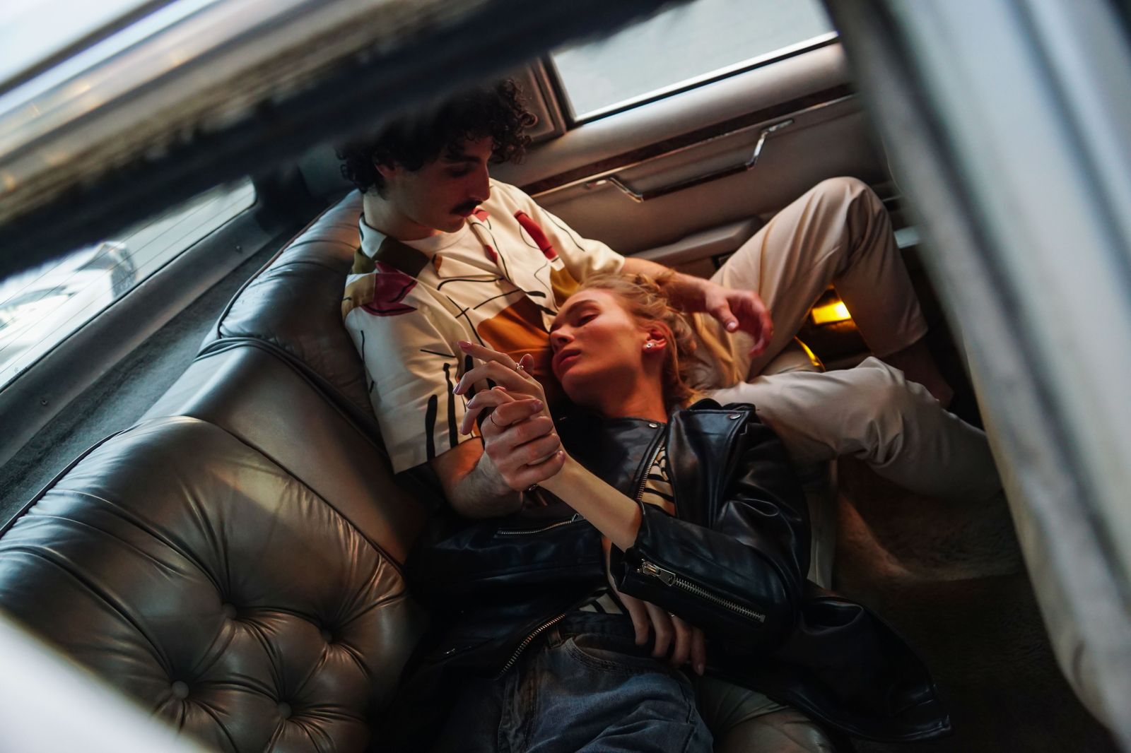 A couple relaxing in the back seat of a luxury car on the way from Niagara Falls to Hamilton